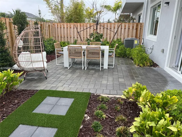 a view of a chair and table in backyard of the house