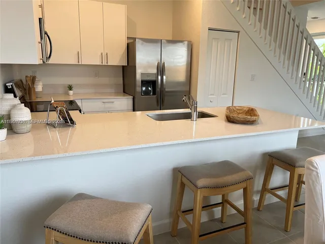 a kitchen with a table chairs and a refrigerator