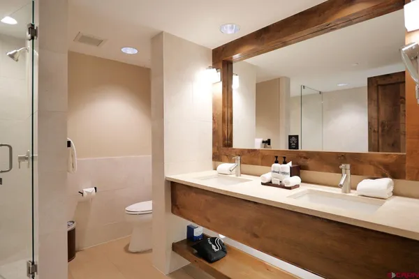 a bathroom with a sink a toilet and shower