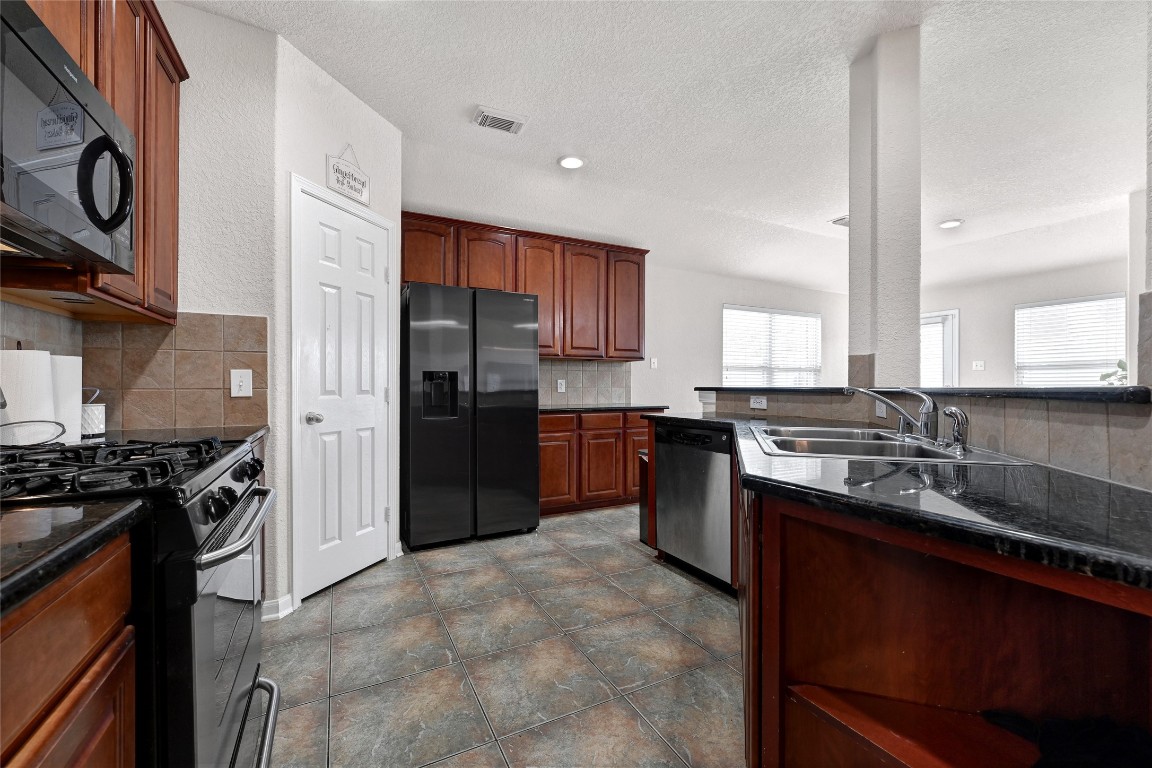 3114 Rendezvous Court Spring, TX 77373 - Photo 15 of 24 a kitchen with stainless steel appliances granite countertop a stove sink and refrigerator