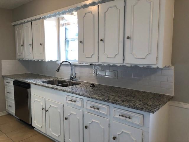 901 Downing Street Forney, TX 75126 - Photo 3 of 14 a kitchen with granite countertop white cabinets and sink