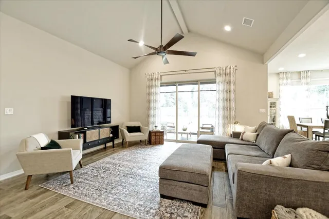 a living room with furniture and a view of kitchen