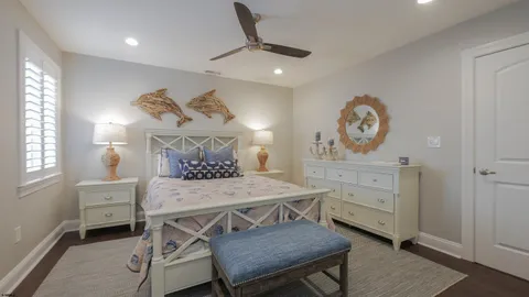 a bedroom with a bed a chandelier and a dresser