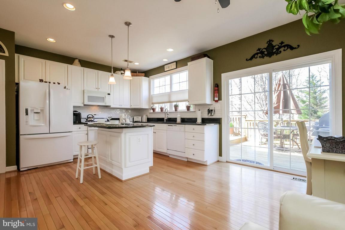 15626 Avocet Loop Woodbridge, VA 22191 - Photo 8 of 30 a kitchen with granite countertop white cabinets white appliances a sink and a large window