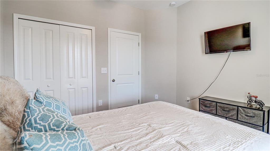 31632 Blue Passing Loop Wesley Chapel, FL 33545 - Photo 40 of 48 a bedroom with a bed and a flat screen tv