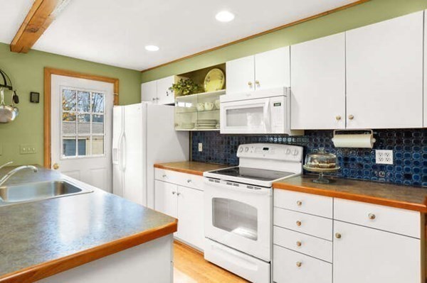 32 Thorpe Road Needham, MA 02494 - Photo 4 of 20 a kitchen with stainless steel appliances granite countertop a sink a stove and white cabinets