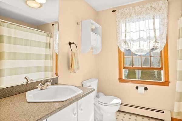 32 Thorpe Road Needham, MA 02494 - Photo 9 of 20 a bathroom with a sink a mirror a toilet and a window