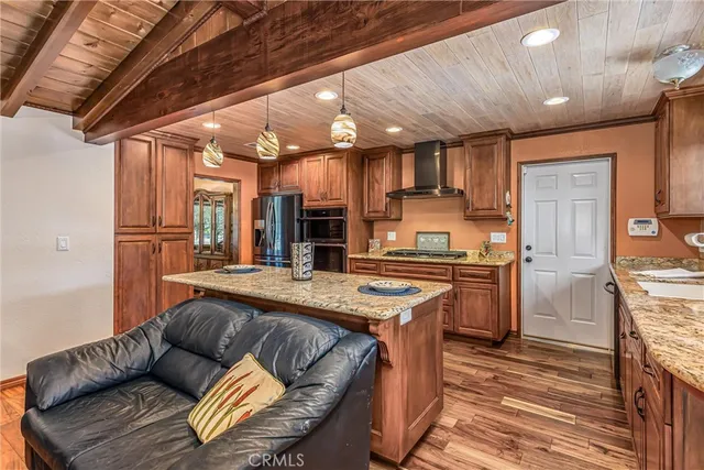 a kitchen with stainless steel appliances granite countertop a sink refrigerator and cabinets