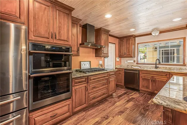 a kitchen with stainless steel appliances granite countertop a stove microwave and sink