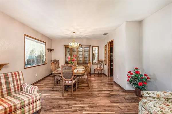 a view of a dining room with furniture a chandelier and wooden floor