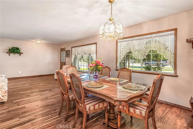 a view of a dining room with furniture a chandelier and wooden floor