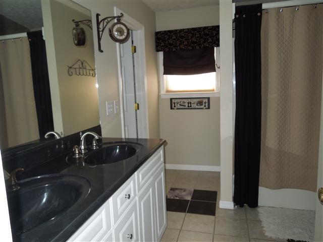 635 Hurricane Loop Tennessee Ridge, TN 37178 - Photo 12 of 20 Master Bath offers tile flooring, double sink vanity, Whirlpool tub/shower combo & then to walk-in closet!