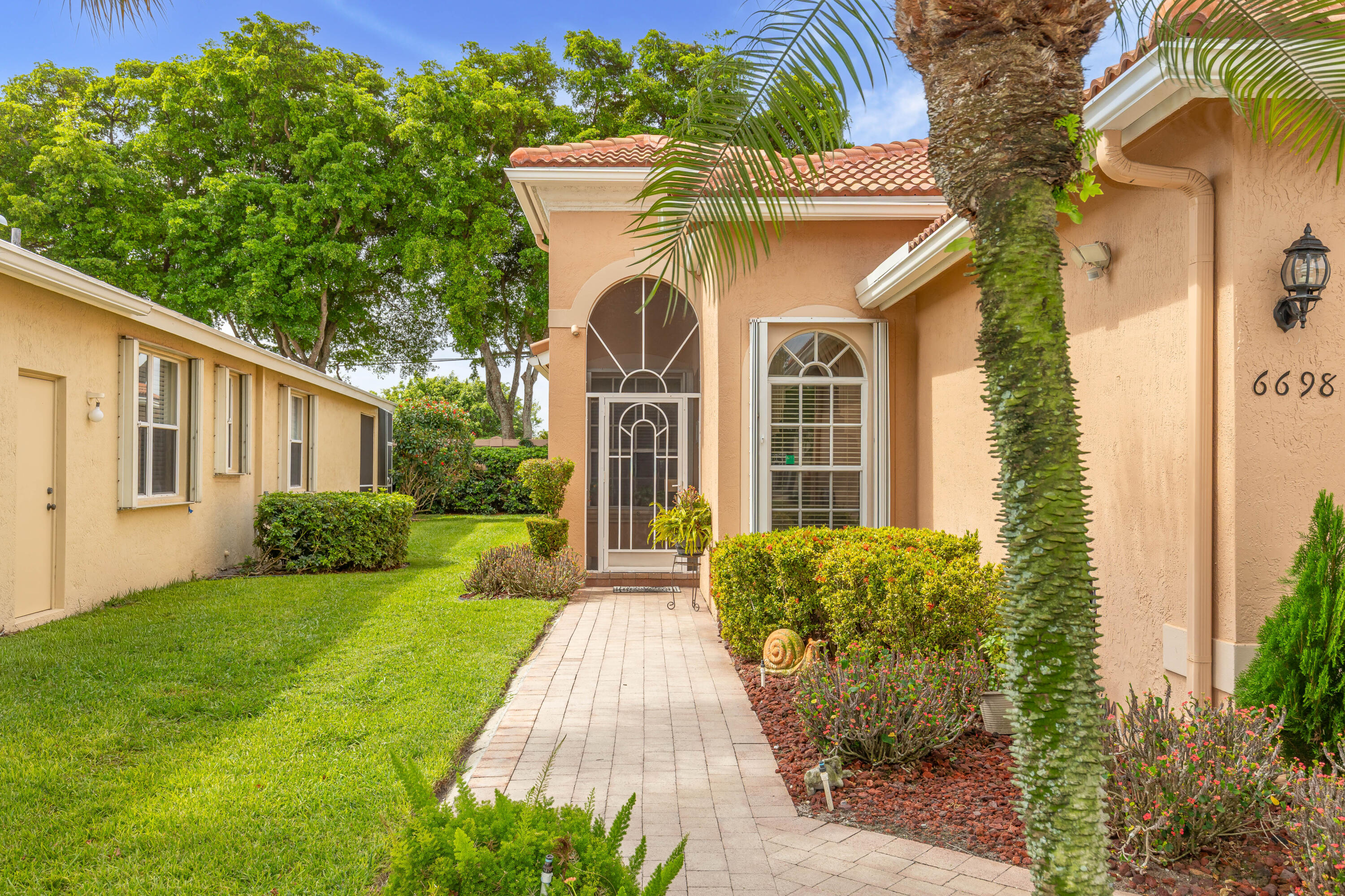 6698 Vía Roma Delray Beach, FL 33446 - Photo 3 of 50 a front view of a house with garden