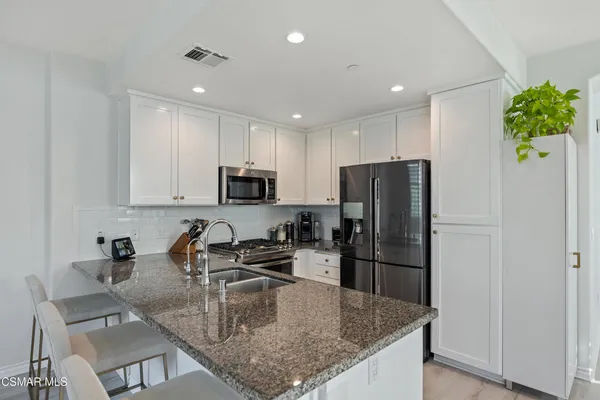a kitchen with kitchen island a counter top space cabinets and stainless steel appliances