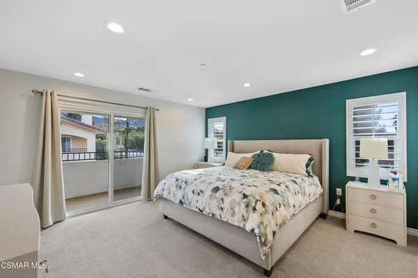 a bedroom with a large bed and a view of living room