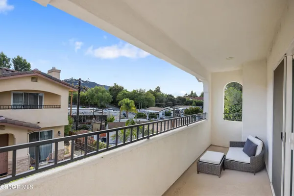 a view of a balcony with two chairs and a table