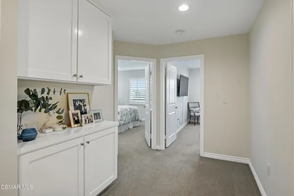 a view of a hallway to closet and mirror