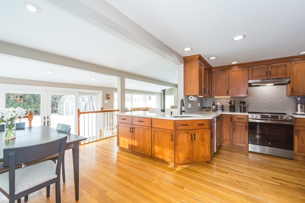 1 Lincoln Street Extension Natick, MA 01760 - Photo 13 of 31 a large kitchen with granite countertop a stove a sink a dining table and chairs