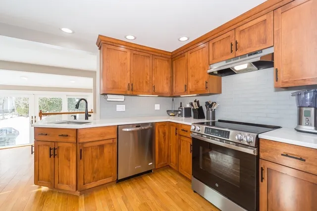 a kitchen with stainless steel appliances granite countertop a sink stove and refrigerator