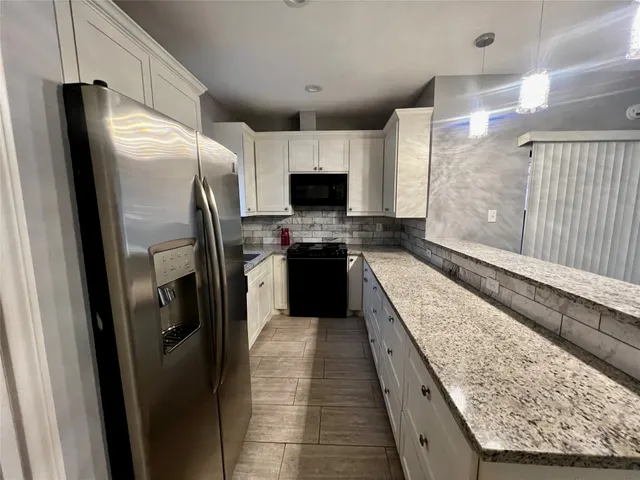 a large kitchen with a stove and a refrigerator