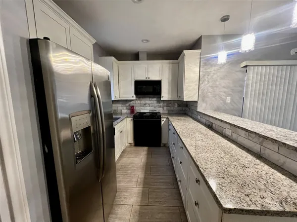 a large kitchen with a stove and a refrigerator