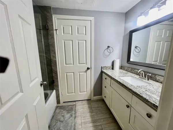 a bathroom with a granite countertop sink and a mirror