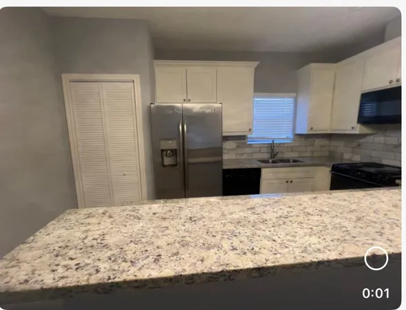 a kitchen with stainless steel appliances kitchen island granite countertop a refrigerator stove and oven