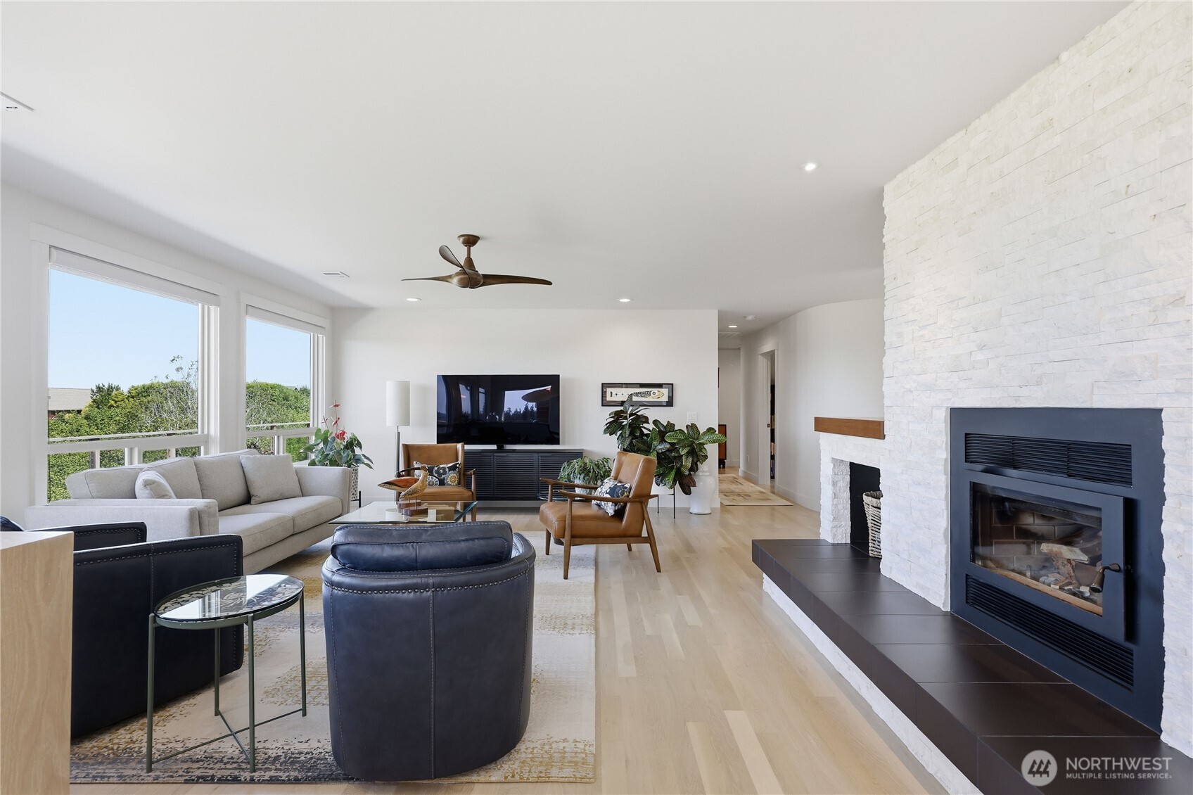 37709 Olympic View Road Northeast Hansville, WA 98340 - Photo 10 of 40 a living room with furniture a fireplace and a floor to ceiling window