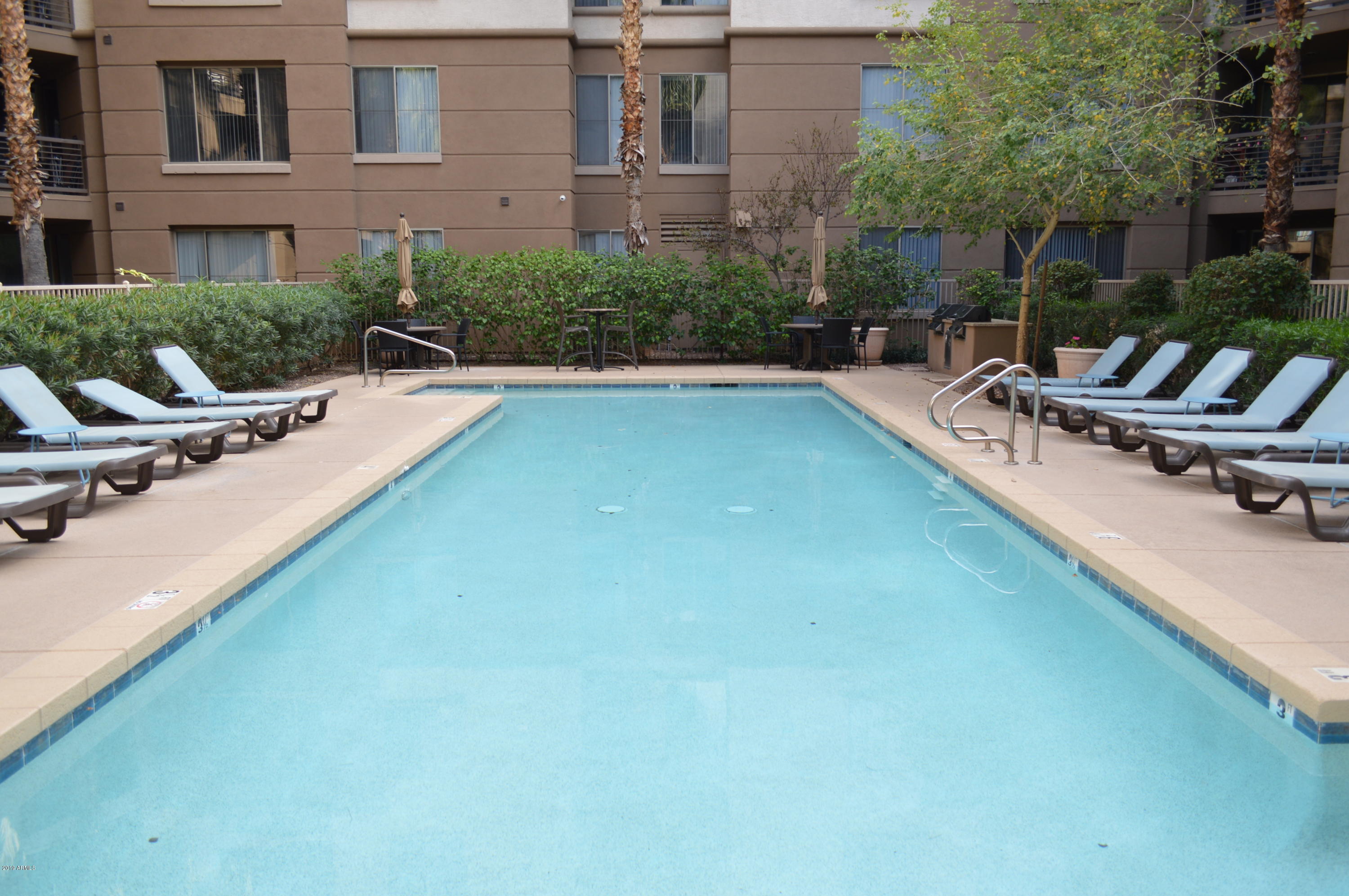 1701 East Colter Street, Unit 184 Phoenix, AZ 85016 - Photo 30 of 41 a swimming pool with outdoor seating and yard