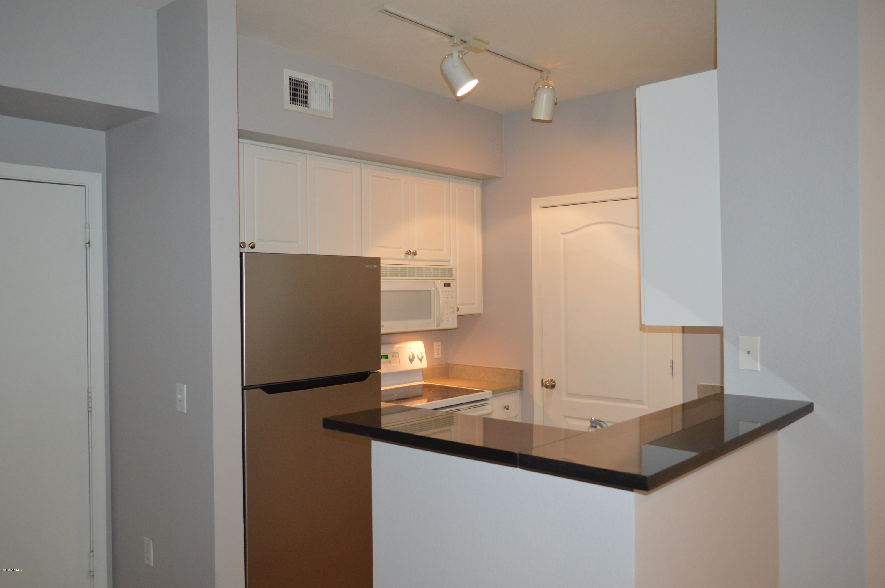 1701 East Colter Street, Unit 184 Phoenix, AZ 85016 - Photo 4 of 41 a kitchen with stainless steel appliances granite countertop a sink and a refrigerator