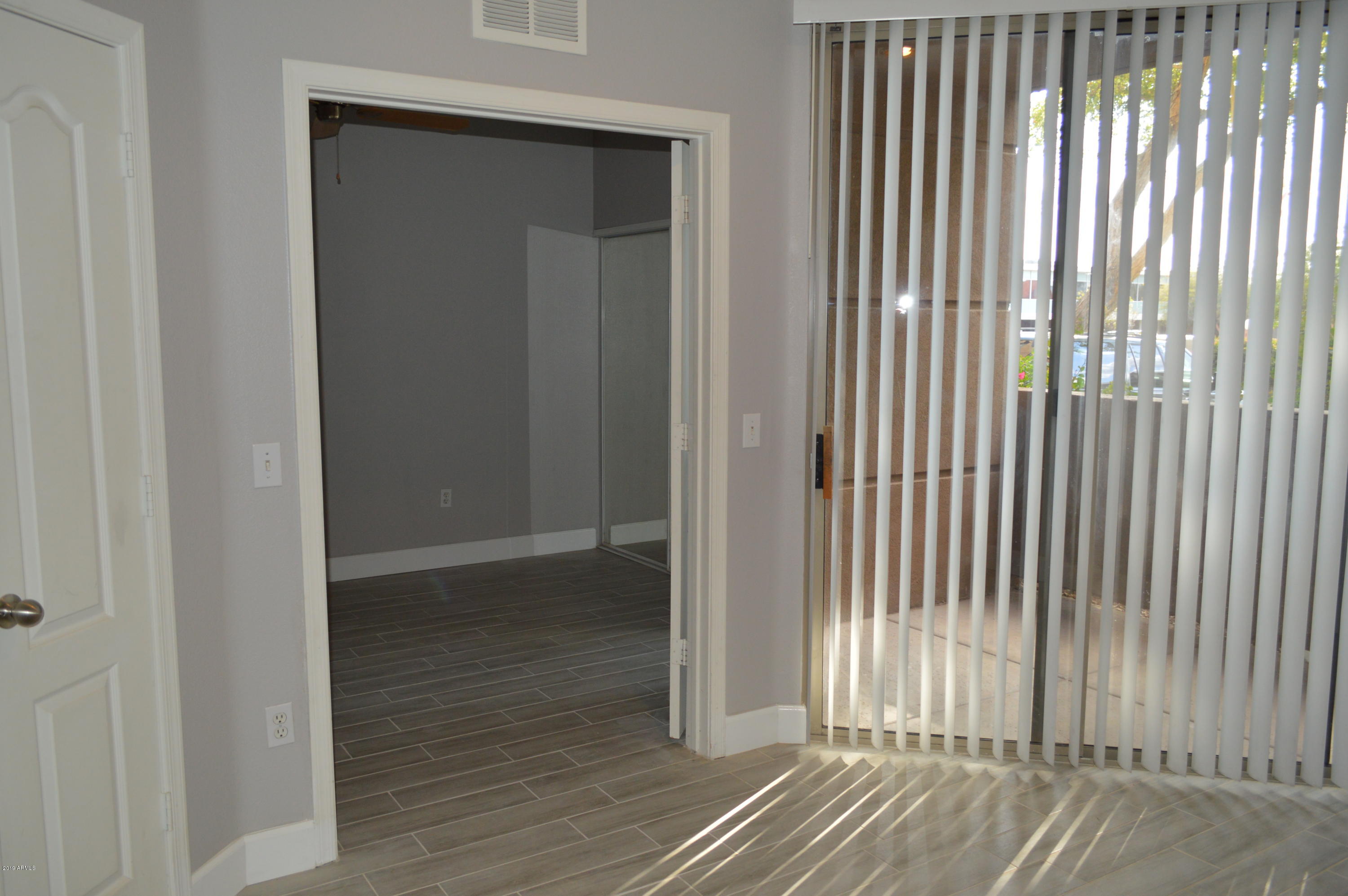 1701 East Colter Street, Unit 184 Phoenix, AZ 85016 - Photo 6 of 41 an empty room with wooden floor and windows