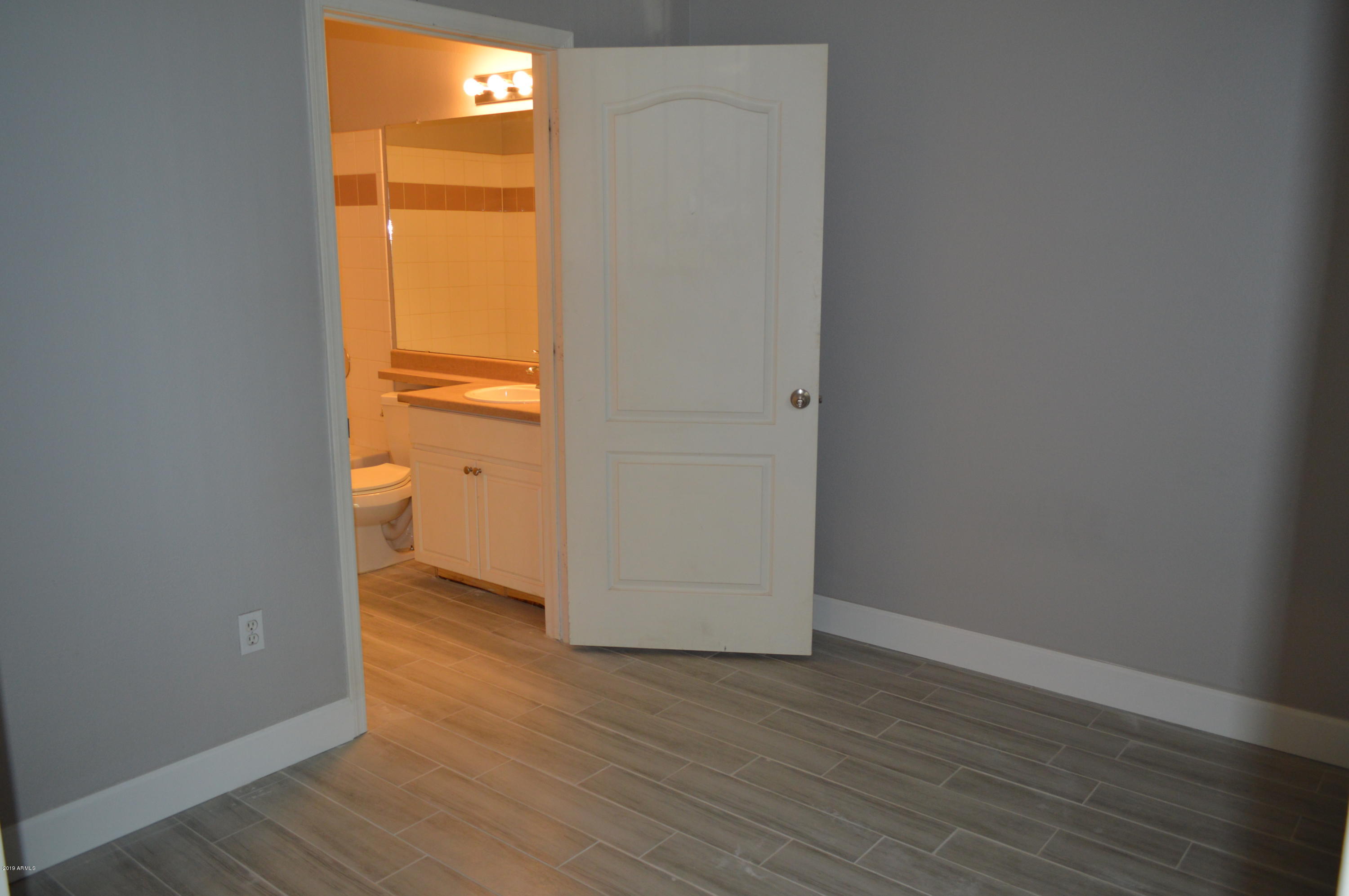 1701 East Colter Street, Unit 184 Phoenix, AZ 85016 - Photo 7 of 41 a view of an empty room and wooden floor and a window