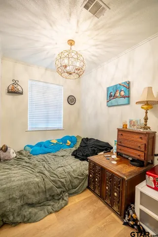a bedroom with a bed and a chandelier