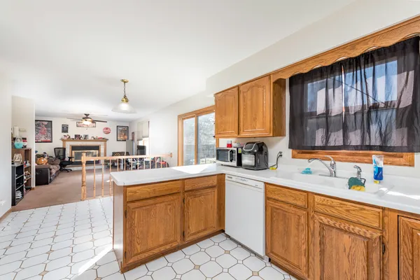 a large kitchen with kitchen island granite countertop a stove a sink a dining table and chairs