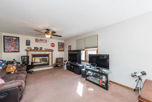 a living room with furniture a fireplace and a flat screen tv