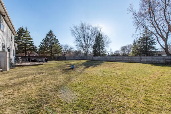 a view of yard with large tree and wooden fence