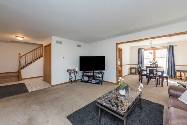 a living room with furniture a flat screen tv and a large window