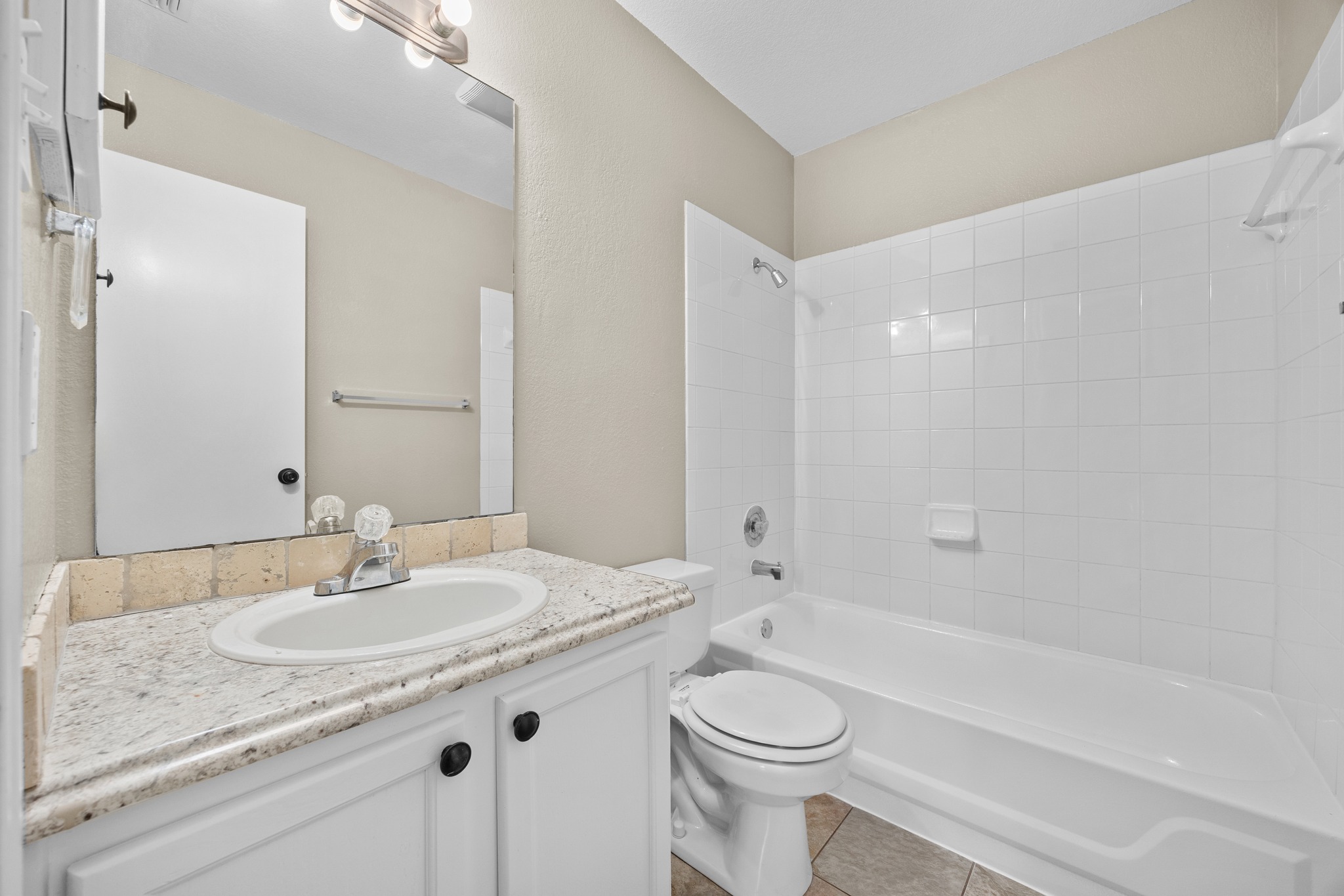 1806 Rusty Nail Loop Round Rock, TX 78681 - Photo 23 of 28 A well-appointed bathroom featuring a clean vanity with a spacious sink, complemented by a pristine bathtub and shower combination.