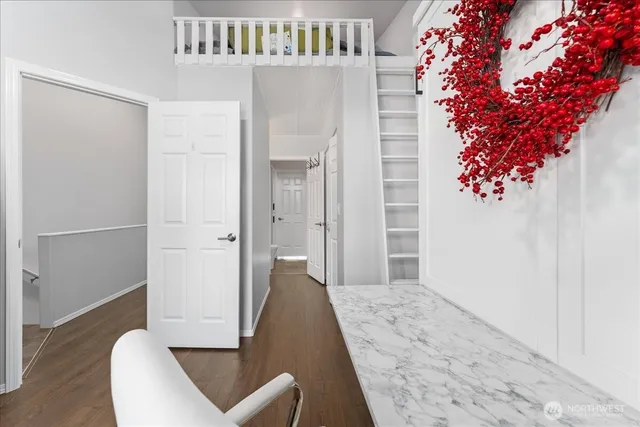 a view of a hallway with wooden floor and staircase