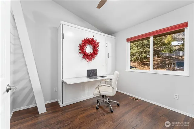 a view of a workspace with furniture and a window