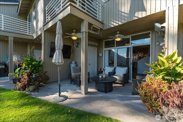 a view of a patio with table and chairs potted plants and floor to ceiling window