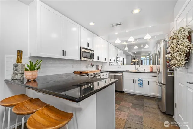 a kitchen with stainless steel appliances granite countertop a sink a stove and a refrigerator