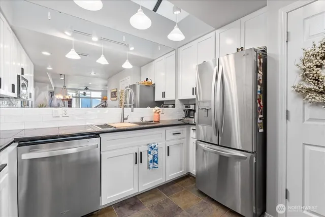 a kitchen with stainless steel appliances a refrigerator sink and microwave