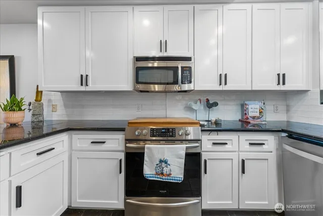 a kitchen with white cabinets and white appliances