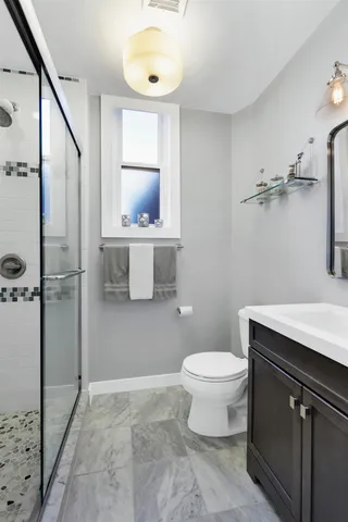 a bathroom with a granite countertop sink toilet and shower