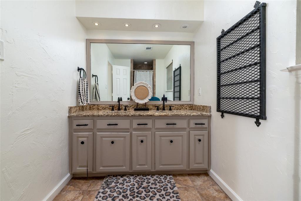 8948 David Fort Road Argyle, TX 76226 - Photo 25 of 39 Double vanity with a granite countertop, dual undermount sinks, and matte black fixtures