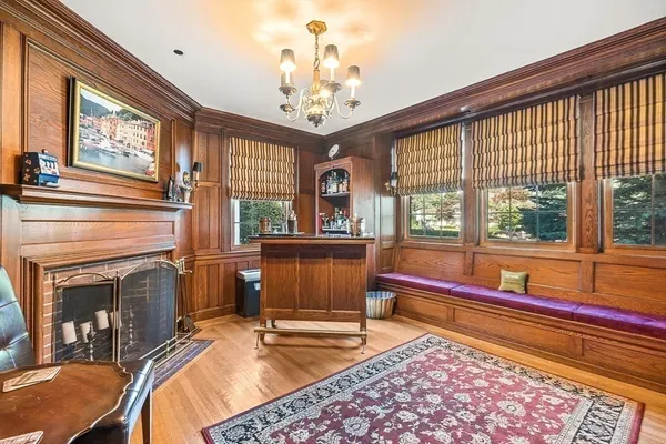 a living room with a large window and a chandelier