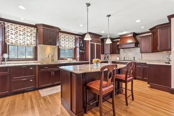 a kitchen with kitchen island granite countertop wooden floors and wooden cabinets