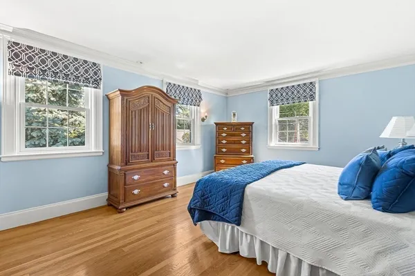 a bedroom with a bed and a dresser next to a window