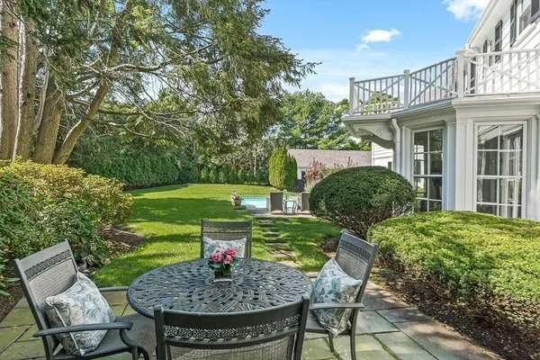 a view of a chair and table in backyard of the house